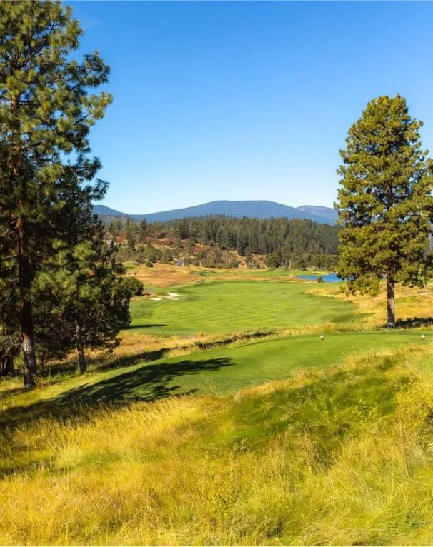 Lush golf course surrounded by trees at Running Y Resort, Oregon, scenic mountain views.