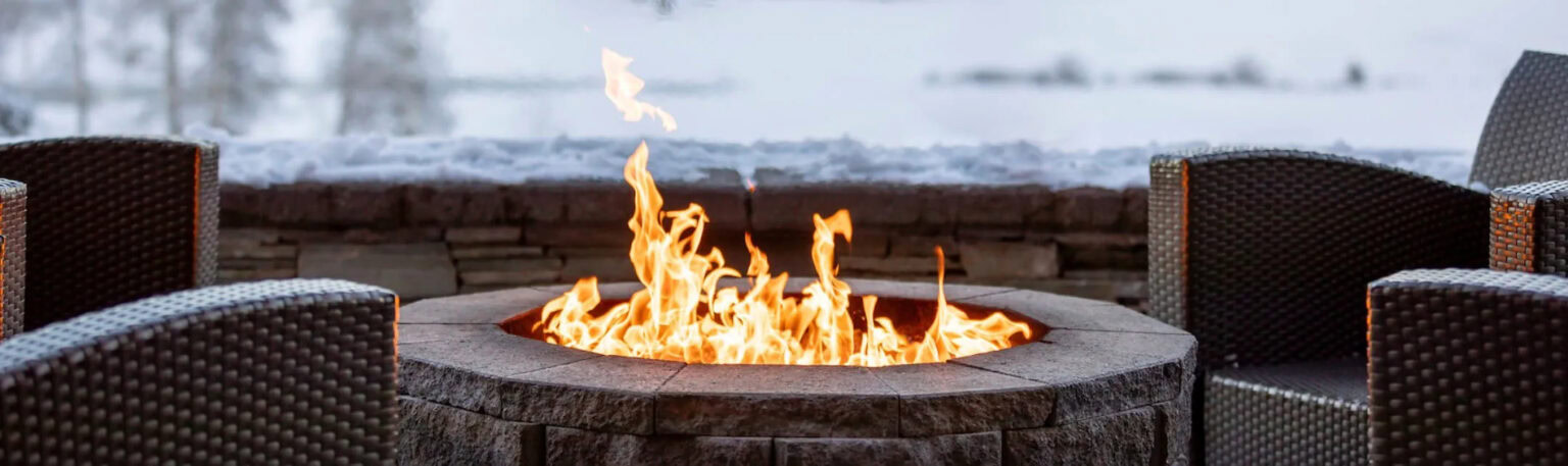 Cozy outdoor fire pit at Running Y Resort in winter scenery.