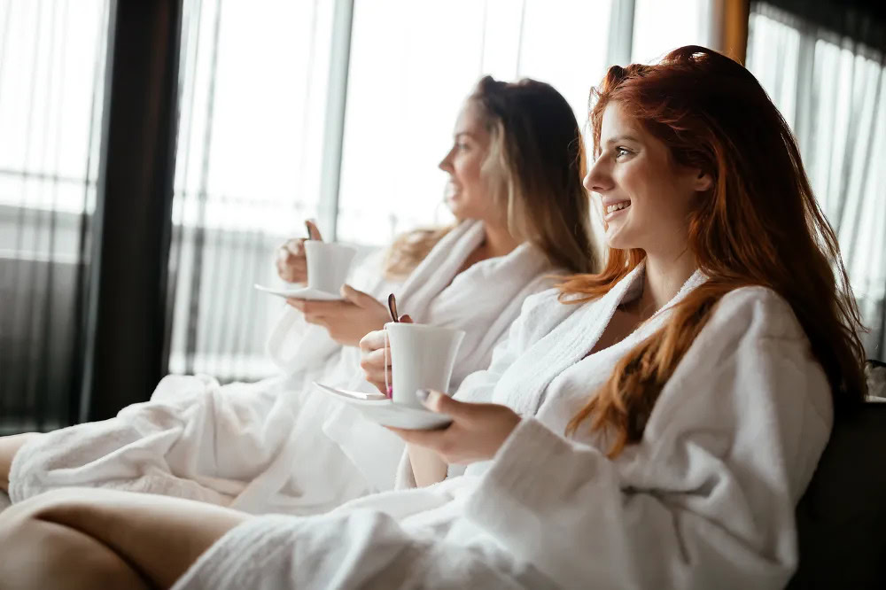 Relaxing women enjoying coffee at Running Y Resort, luxurious spa experience.